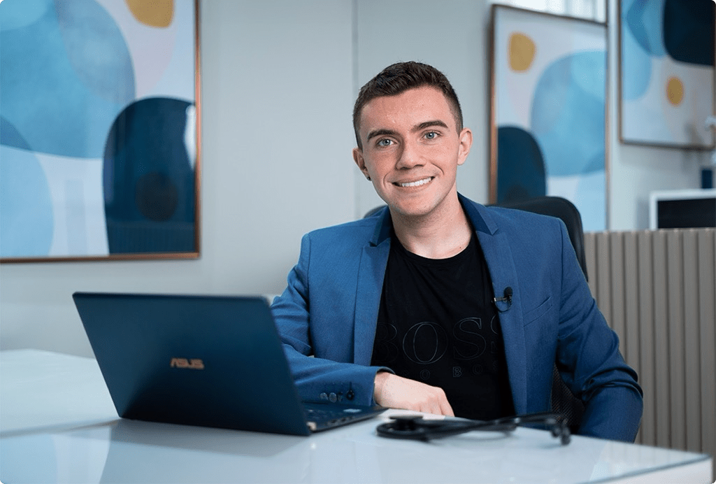 Foto Dr.Renan possando para fota em mesa que tem notebook