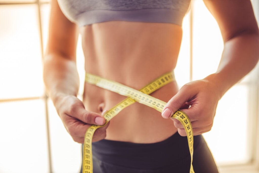 Mulher com fita de medida na barriga