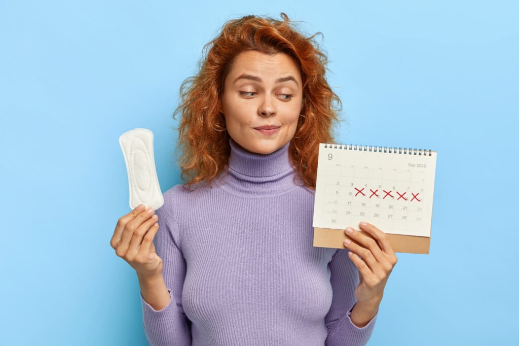 mulher com calendário mostrando dias para acabar ciclo de menstruação